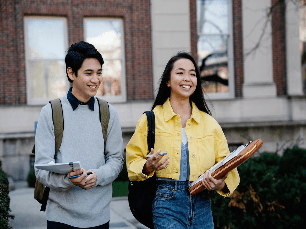 two college students smiling and talking